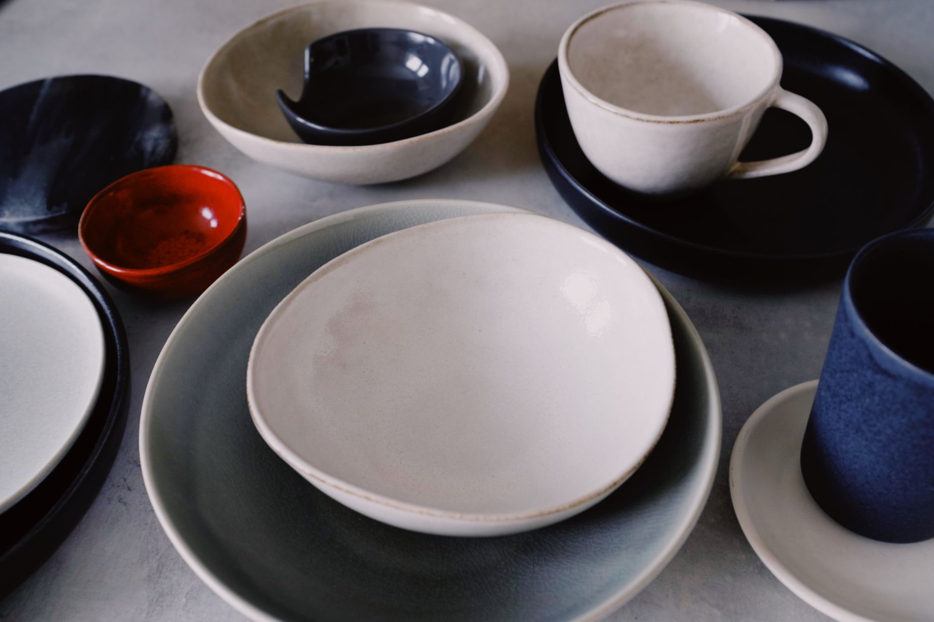 Cream and navy ceramic plates, bowls and a mug arranged on a table