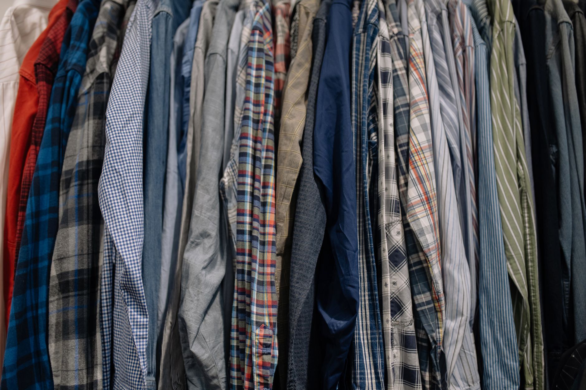 Patterned shirts hanging side by side on a clothes rail