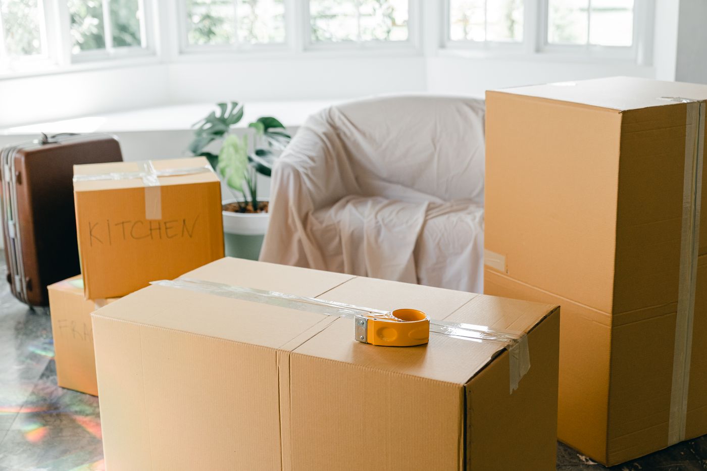 Sealed moving boxes and a suitcase ready in a living room