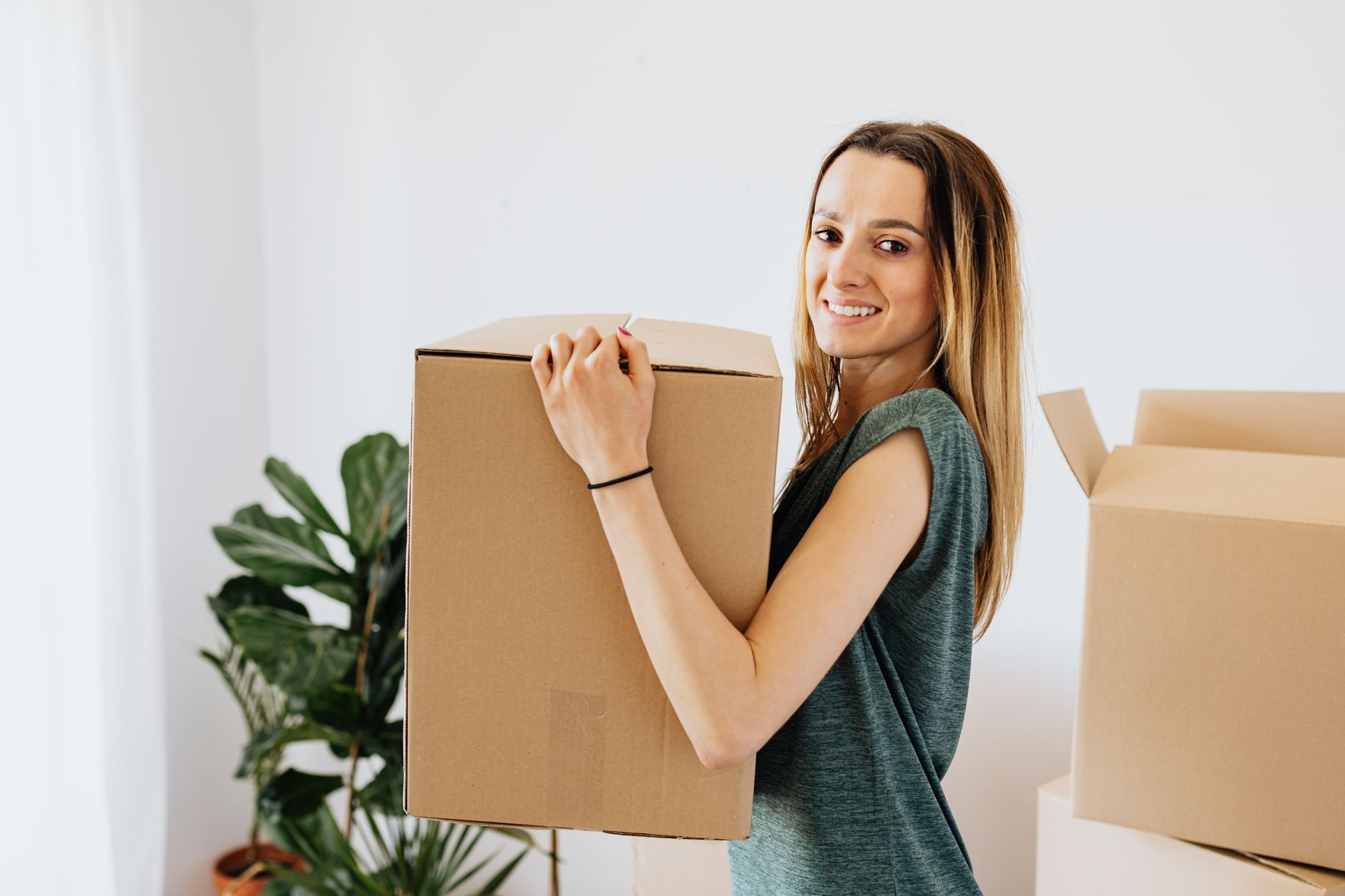 A student carrying a packed cardboard box on moving day