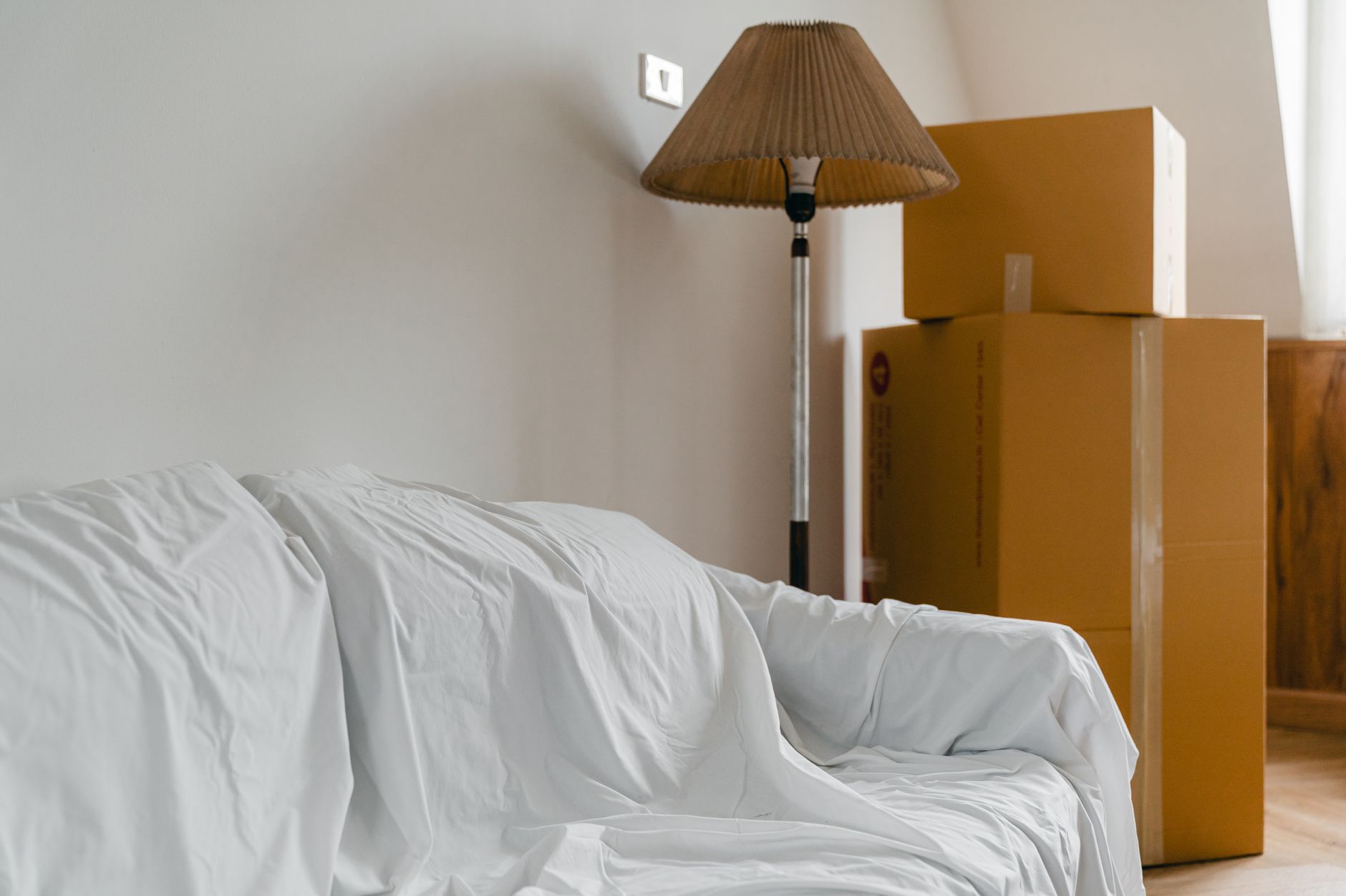 A covered sofa and packed boxes ready for a smaller home move