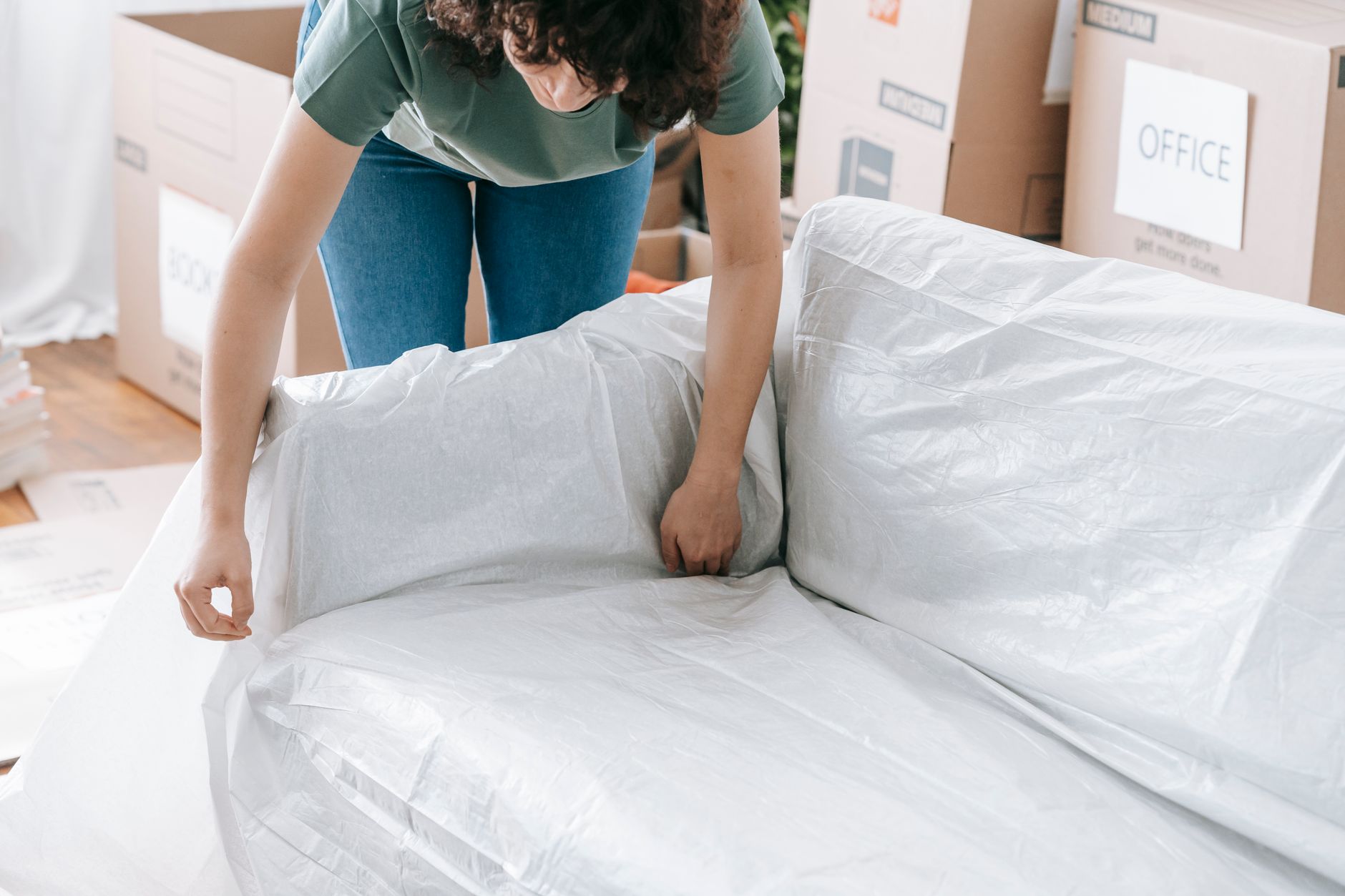 A woman protecting a sofa before a move